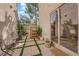 Cozy patio area with tiled floor, metal table and chairs, and lush potted plants for relaxing outdoors at 9926 Swimming Hole St, Las Vegas, NV 89183