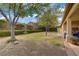 Expansive backyard with manicured lawn, mature trees, and a charming patio area for outdoor enjoyment at 10201 Los Padres Pl, Las Vegas, NV 89134