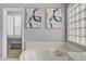 Bathroom featuring soaking tub, block glass window, and abstract art at 10201 Los Padres Pl, Las Vegas, NV 89134