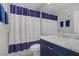 Stylish bathroom featuring blue and white shower curtain, vanity, and framed artwork at 10201 Los Padres Pl, Las Vegas, NV 89134