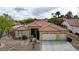 Attractive single-story home with a tile roof, desert landscaping, and a two-car garage at 10201 Los Padres Pl, Las Vegas, NV 89134
