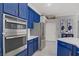 A kitchen with custom blue cabinetry, stainless steel appliances, and elegant white marble countertops at 10201 Los Padres Pl, Las Vegas, NV 89134