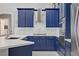 Modern kitchen with blue cabinets, marble countertops, and stainless appliances at 10201 Los Padres Pl, Las Vegas, NV 89134
