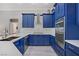 Well-appointed kitchen with blue cabinets, marble counters, and modern appliances at 10201 Los Padres Pl, Las Vegas, NV 89134