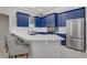 Contemporary kitchen featuring blue cabinetry, marble countertops, and bar seating at 10201 Los Padres Pl, Las Vegas, NV 89134