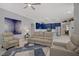 Open floor plan showcasing living room adjacent to modern blue kitchen and dining area at 10201 Los Padres Pl, Las Vegas, NV 89134