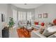 Comfortable living room with bright windows, neutral sofas, vibrant rug, and stylish decor at 10201 Los Padres Pl, Las Vegas, NV 89134