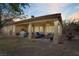 Inviting covered patio with an outdoor kitchen, seating, fan, and a serene view of the well-maintained backyard at 10201 Los Padres Pl, Las Vegas, NV 89134