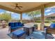 Inviting covered patio with comfortable seating, ceiling fan, and view of the well-maintained backyard at 10201 Los Padres Pl, Las Vegas, NV 89134