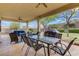 Covered patio featuring an outdoor dining table, seating, and manicured yard at 10201 Los Padres Pl, Las Vegas, NV 89134