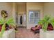 Inviting front porch with tile flooring, comfortable seating, and lush potted plants at 10201 Los Padres Pl, Las Vegas, NV 89134