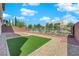 Well-maintained backyard featuring artificial turf, decorative rock, and a secure perimeter fence at 10254 Kesington Dr, Las Vegas, NV 89135