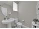 Bathroom featuring a pedestal sink, toilet, and round mirror at 10254 Kesington Dr, Las Vegas, NV 89135