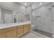 Modern bathroom featuring dual sinks, a large mirror, and glass-enclosed shower with seating at 10254 Kesington Dr, Las Vegas, NV 89135