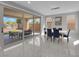 Elegant dining room with marble floors, modern chandelier, and sliding glass doors to patio at 10254 Kesington Dr, Las Vegas, NV 89135