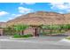 Stone entrance and iron gate into an upscale community with mountain views in the background at 10254 Kesington Dr, Las Vegas, NV 89135
