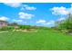 A well-manicured lawn surrounded by landscaped areas with trees and shrubs under a clear blue sky at 10254 Kesington Dr, Las Vegas, NV 89135