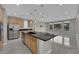 A spacious kitchen featuring an island with a black countertop, stainless steel appliances, and modern lighting fixtures at 10254 Kesington Dr, Las Vegas, NV 89135