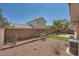 Backyard with stone perimeter, artificial turf, and brick fencing at 10719 Tottenham Ave, Las Vegas, NV 89135