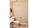 A half-bathroom featuring tile floors, a sink, a toilet, and decorative fixtures at 10719 Tottenham Ave, Las Vegas, NV 89135