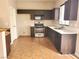 Well-lit kitchen featuring dark cabinets, stainless steel appliances, and easy-to-clean tile flooring at 10719 Tottenham Ave, Las Vegas, NV 89135