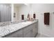This bathroom features a granite sink with a large mirror and brown towel racks at 10987 Kingston Fields Ave, Las Vegas, NV 89166