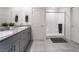 Well-lit bathroom with dual sinks, granite counters, and tiled shower for a spa-like experience at 10987 Kingston Fields Ave, Las Vegas, NV 89166