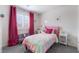 This bright bedroom has a multicolored bed and colorful decor and curtains at 10987 Kingston Fields Ave, Las Vegas, NV 89166