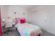 This bright bedroom has a multicolored bed and a small, white desk at 10987 Kingston Fields Ave, Las Vegas, NV 89166