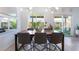 Modern dining area featuring a table with seating, large windows overlooking a well-manicured backyard at 10987 Kingston Fields Ave, Las Vegas, NV 89166