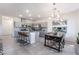 Bright, open kitchen and dining area, featuring stainless steel appliances, gray cabinets, and an island with counter seating at 10987 Kingston Fields Ave, Las Vegas, NV 89166