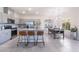 Modern kitchen with stainless steel appliances, gray cabinets, and large island with seating, open to dining area at 10987 Kingston Fields Ave, Las Vegas, NV 89166