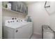 This laundry room has a white washer and dryer and a rack at 10987 Kingston Fields Ave, Las Vegas, NV 89166