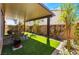 This covered patio has artificial grass, a brick perimeter, and a brick wall at 10987 Kingston Fields Ave, Las Vegas, NV 89166