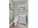 Elegant powder room featuring patterned wallpaper, stylish vanity, and modern fixtures at 11 Caminito Amore, Henderson, NV 89011