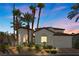 Elegant home boasts a tile roof, arched entryway, mature palm trees, and lush landscaping at 11 Caminito Amore, Henderson, NV 89011