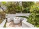 Cozy outdoor fire pit with built-in seating, lush landscaping, and privacy at 11 Caminito Amore, Henderson, NV 89011