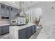 Open kitchen with gray cabinets, stainless steel appliances, and a large island at 11 Caminito Amore, Henderson, NV 89011