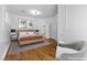 Virtually staged bedroom with hardwood floors, a sitting area, and elegant wall decor at 11 Caminito Amore, Henderson, NV 89011
