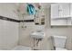 Bathroom with white tile shower, sink, toilet, and cabinet at 1317 Pyramid Dr, Las Vegas, NV 89108