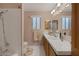 Bright bathroom featuring walk-in shower with showerhead, white tile, and long wooden vanity at 146 Cascade Dr, Henderson, NV 89074