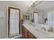 Bright bathroom features double sinks, tile countertops, and decorative white shower curtain on glass paneled door at 146 Cascade Dr, Henderson, NV 89074