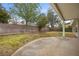 Private backyard with a covered patio, block fencing, mature trees, and ample space for outdoor activities at 1513 Marita Dr, Boulder City, NV 89005