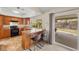 Galley-style kitchen with tile flooring, light wood cabinetry, a breakfast bar, and a sliding glass door at 1513 Marita Dr, Boulder City, NV 89005