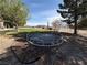 Backyard view featuring a trampoline, trees, a house, and other outdoor elements at 1540 Labrador St, Pahrump, NV 89048