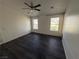 This bedroom features dark laminate flooring, a ceiling fan and dual windows for natural light at 1540 Labrador St, Pahrump, NV 89048