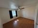 This bedroom has wood laminate flooring, a ceiling fan and a window with natural light at 1540 Labrador St, Pahrump, NV 89048