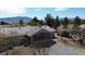 A single story home with a patio, neutral exterior, surrounded by mature trees, set against a mountain backdrop at 1540 Labrador St, Pahrump, NV 89048