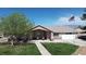 Charming single-story home with a well-kept lawn, a walkway and an American flag at 1540 Labrador St, Pahrump, NV 89048