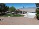 Home featuring an American flag, a front porch, a mature tree and a large driveway at 1540 Labrador St, Pahrump, NV 89048